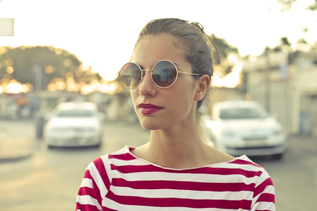 Portrait of a fashionable woman in sunglasses and striped shirt, Mgarr street, Malta.